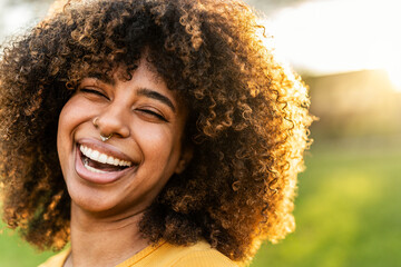 Happy young black woman smiling outside - Joyful beautiful girl laughing outdoors - Positive emotions, people portrait life style photo concept