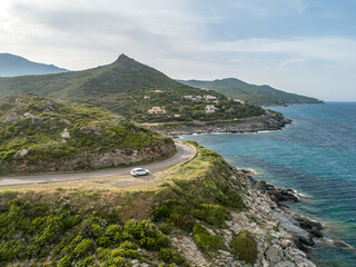 Aerial view car Roadtrip Winding road along rocky coast of Cap Corse peninsula on Corsica island France