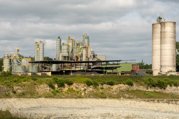 Industrial plant processing materials under cloudy sky