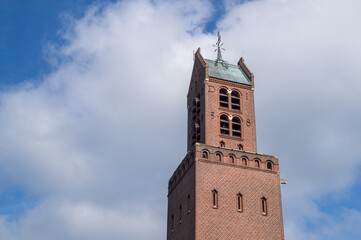 Church tower reaching for the cloudy sky in the netherlands