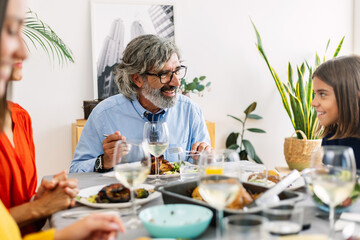 Happy family enjoying a healthy lunch together, sharing good moments and conversation around the dining table