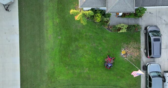 Lawn care service. Worker cutting grass with zero turn lawn mover tractor.