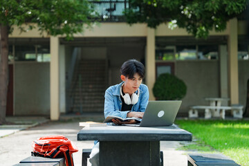 College student studying on campus outdoor with laptop casual lifestyle.