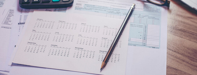 Planning Budget and Tax Concept.Calendar 2025, Individual Income 1040 Tax Form, and calculator for individual income. According to United States, season to pay and deadline for tax payment-banner.