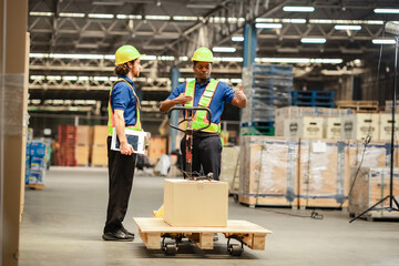 Warehouse employees in reflective vests coordinate tasks while transporting goods on a pallet...