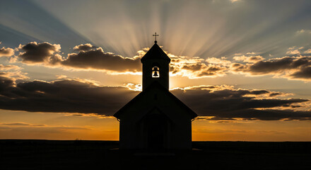 Silhouette of a small church against a dramatic sky. The sun is setting or rising behind the church, casting rays of light through the clouds.