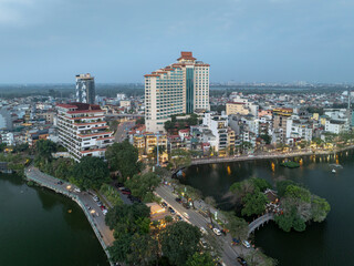 Explore the beauty of West Lake in Hanoi at dusk with vibrant city life along the water's edge