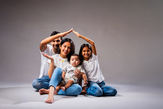 Asian family making roof with hands to express love, safety, and real estate investment values
