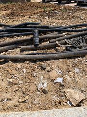 Old dirty hoses scattered on ground at construction site, gritty industrial scene, suitable for themes of urban decay, construction, and infrastructure