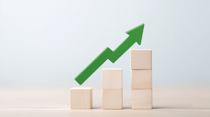 Green arrow pointing upward above wooden blocks signifying growth and progress.