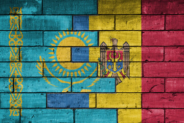 Fototapeta premium colourful painted big national flag of moldova and flag of kazakhstan on a massive old brick wall background. concept