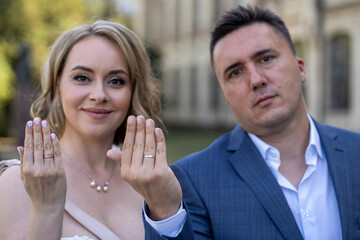 A husband and wife showing their hands with wedding rings. Portrait of happy young just-married couple in love. Wedding ring on finger 