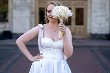 portrait of beautiful young bride in white wedding dress holding bouquet of flowers. wedding day....