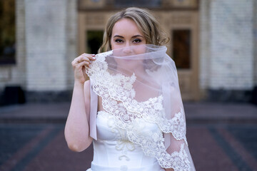portrait of beautiful young bride in white wedding dress holding bouquet of flowers. wedding day....