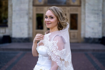 portrait of beautiful young bride in white wedding dress holding bouquet of flowers. wedding day....