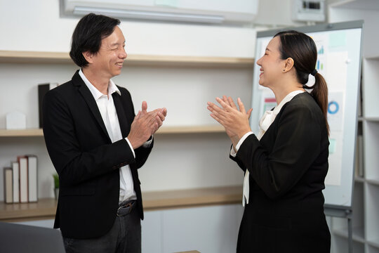 Celebrating Business Success. Professionals sharing a joyful moment in a modern office. - Powered by Adobe