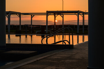 Golden Sunset Reflected in Pool Water at Mediterranean Resort