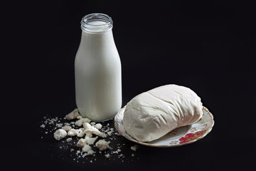 Bottle of milk with mozzarella cheese on a plate and feta crumbles, dairy 
