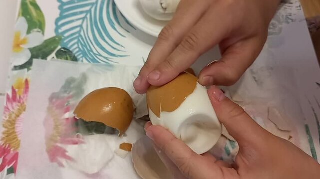 nine year old girl cracking brown egg shell while preparing food on table