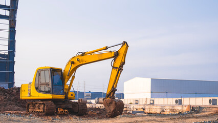 Excavator is leveling the ground inside of factory construction site in industrial settlement area
