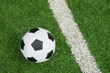 Soccer Ball on Green Grass Field with White Line. Football stadium background. View from above.