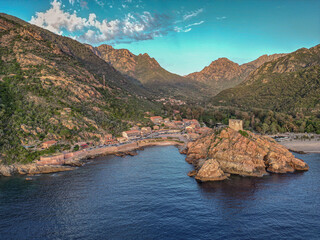 Aerial view town ruins Genoese tower of Porto Corsica France medieval watchtower Mediterranean Sea Calanches de Piana