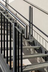 Sleek staircase features metal railings and patterned steps, offering modern touch to space....
