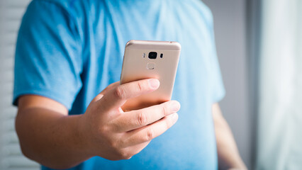 Person using smartphone at home indoor environment casual lifestyle modern technology close-up perspective