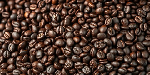 Fototapeta premium Dark roasted coffee beans cascading onto a pile of others, aroma, cascade