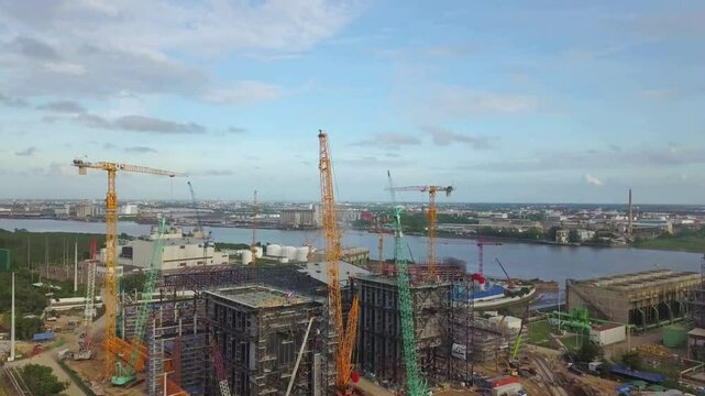 Aerial View of Industrial Construction Site with Cranes and Storage Tanks