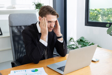 Caucasian businessman grab his head suffer from headache