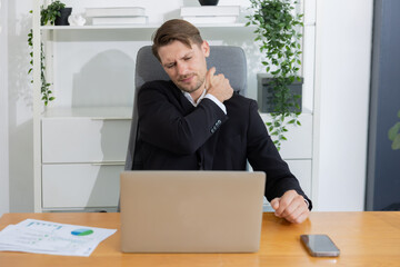 Caucasian businessman with neck and shoulder pain suffer from office syndrome