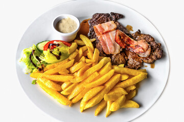 2 steak with fried bacon, french fries and sauce, closeup.
