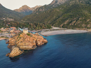 Aerial view town ruins Genoese tower of Porto Corsica France medieval watchtower Mediterranean Sea Calanches de Piana