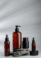 Elegant brown and black cosmetic bottles displayed on natural wooden base