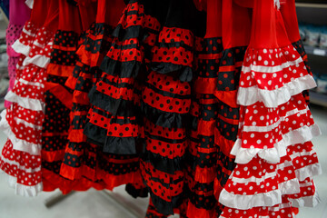 Colorful red and black polka dot dresses hanging in a retail store showcasing vibrant fashion and...