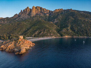 Aerial view town ruins Genoese tower of Porto Corsica France medieval watchtower Mediterranean Sea Calanches de Piana