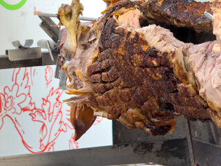 Juicy roasted meat with crispy skin on a spit