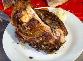 Deliciously crispy roast pork dish with shredded cabbage on white plate
