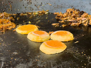 Grilled mexican gorditas with savory toppings on hot griddle