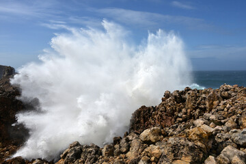 big waves breaking at a cliff in the western Algarve of Portugal