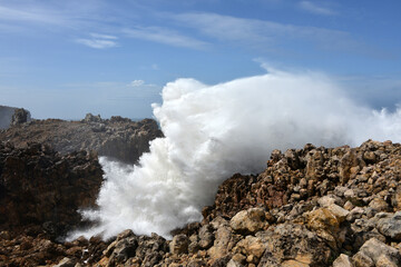 big waves breaking at a cliff in the western Algarve of Portugal