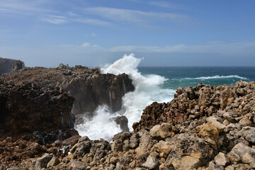 big waves breaking at a cliff in the western Algarve of Portugal