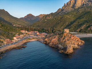 Aerial view town ruins Genoese tower of Porto Corsica France medieval watchtower Mediterranean Sea Calanches de Piana