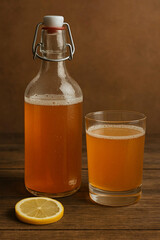 Homemade Kombucha in Glass Bottle and Cup with Lemon Slice &ndash; Fermented Healthy Drink