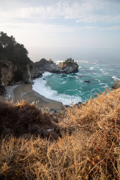 Iconic McWay Falls Cascading onto a Secluded Beach in a Turquoise Cove at Sunset in Big Sur, California