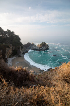 Iconic McWay Falls Cascading onto a Secluded Beach in a Turquoise Cove at Sunset in Big Sur, California