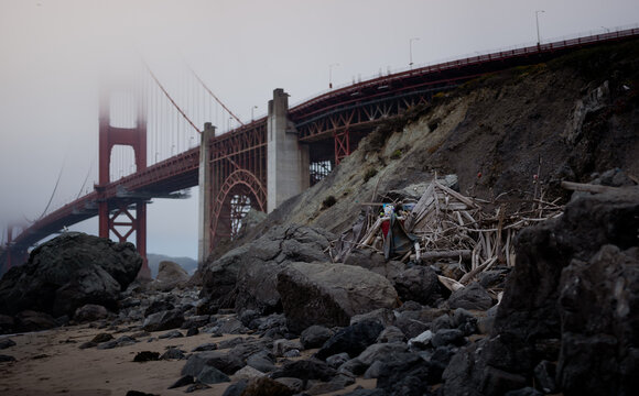 The Golden Gate Bridge in San Francisco, California disappears into the fog, as seen from the beach.