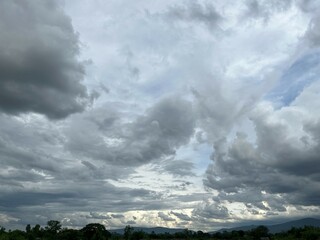 Dramatic Gray Clouds Over Landscape with Distant Mountains at Dusk
