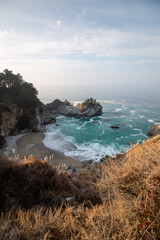 Iconic McWay Falls Cascading onto a Secluded Beach in a Turquoise Cove at Sunset in Big Sur, California